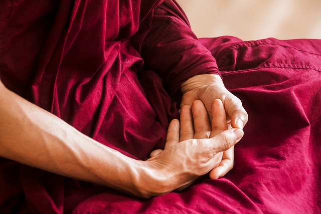 A monk with his hands together while meditating 