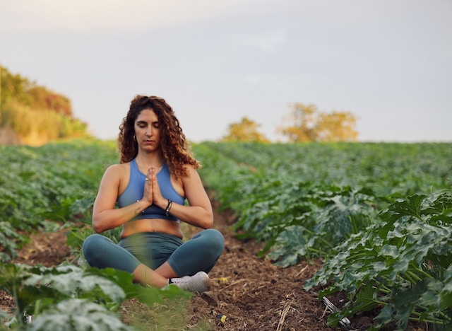A woman meditating in the middle of a field