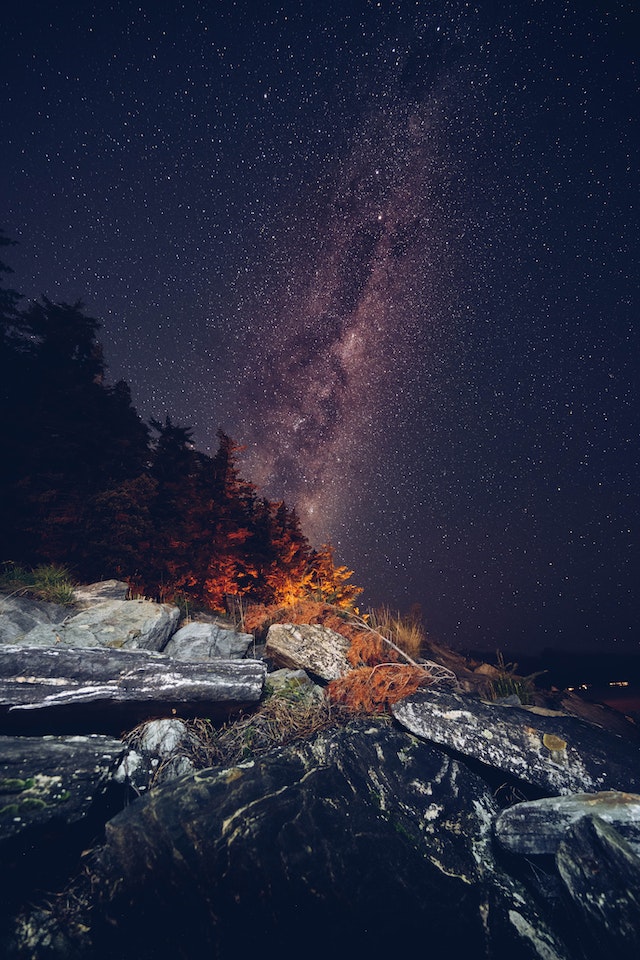 The Milky Way galaxy seen from atop a rocky hill at night