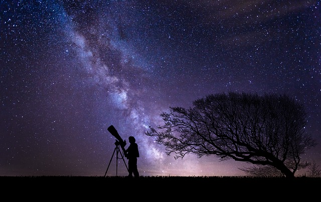 Person with a telescope under the staryy skies