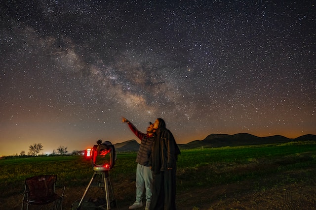 Couple stargazing at night in the fields