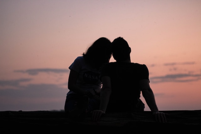 Silhouette of a couple sitting side by side