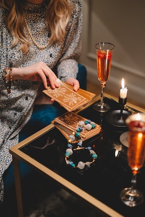 Person using tarot cards and crystal beads