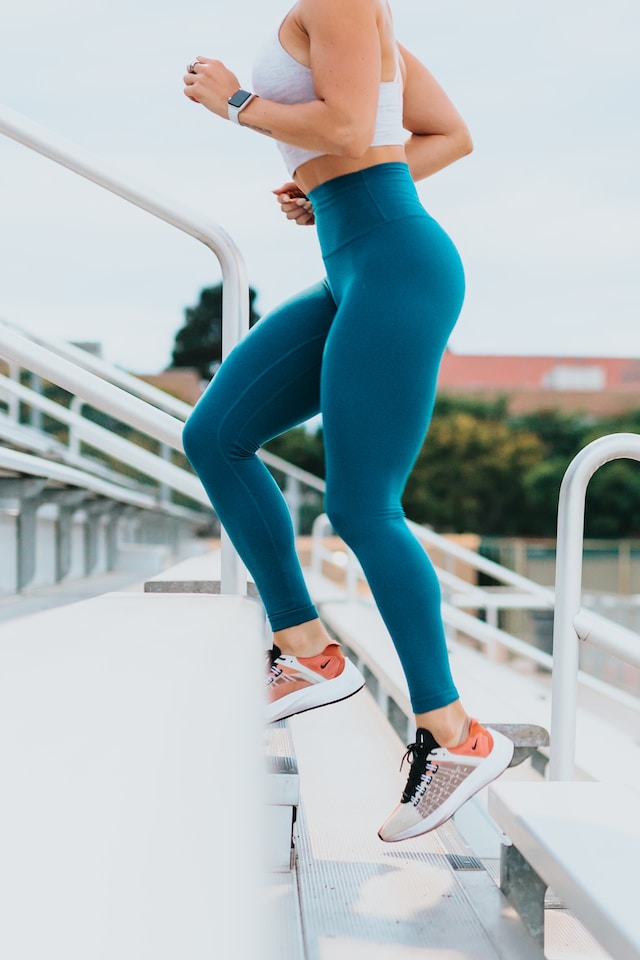 Woman in blue legging working out on a flight of stairs